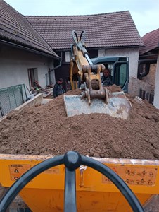 Dampr převáží zeminu na dvoře rodinného domu